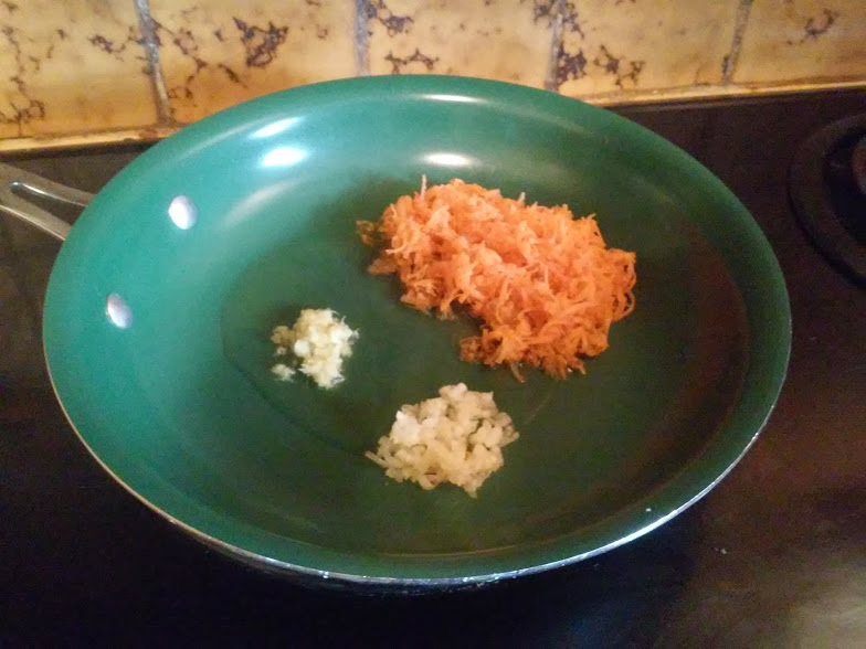 Garlic, ginger and carrots in fry pan with oil